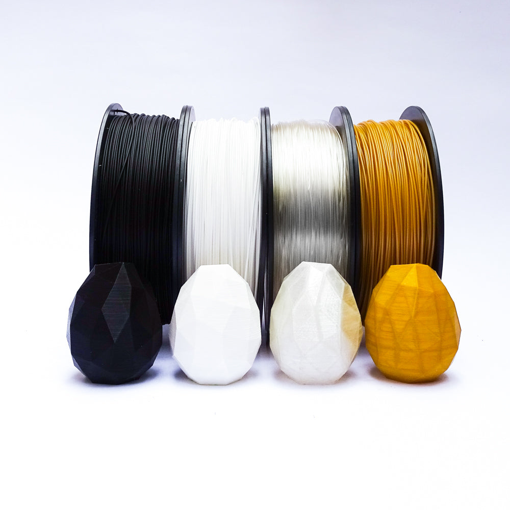 Cuatro Rollos de filamento PLA Print3x Negro, blanco, transparente y dorado más huevos | printex printec print3c